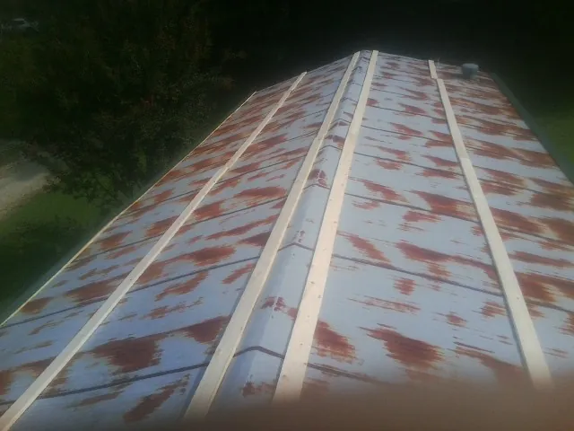 Rusted metal roof panels with new wood purlins before replacement — Storm Damage Roof Repair in Harbeson by Roofing Brothers