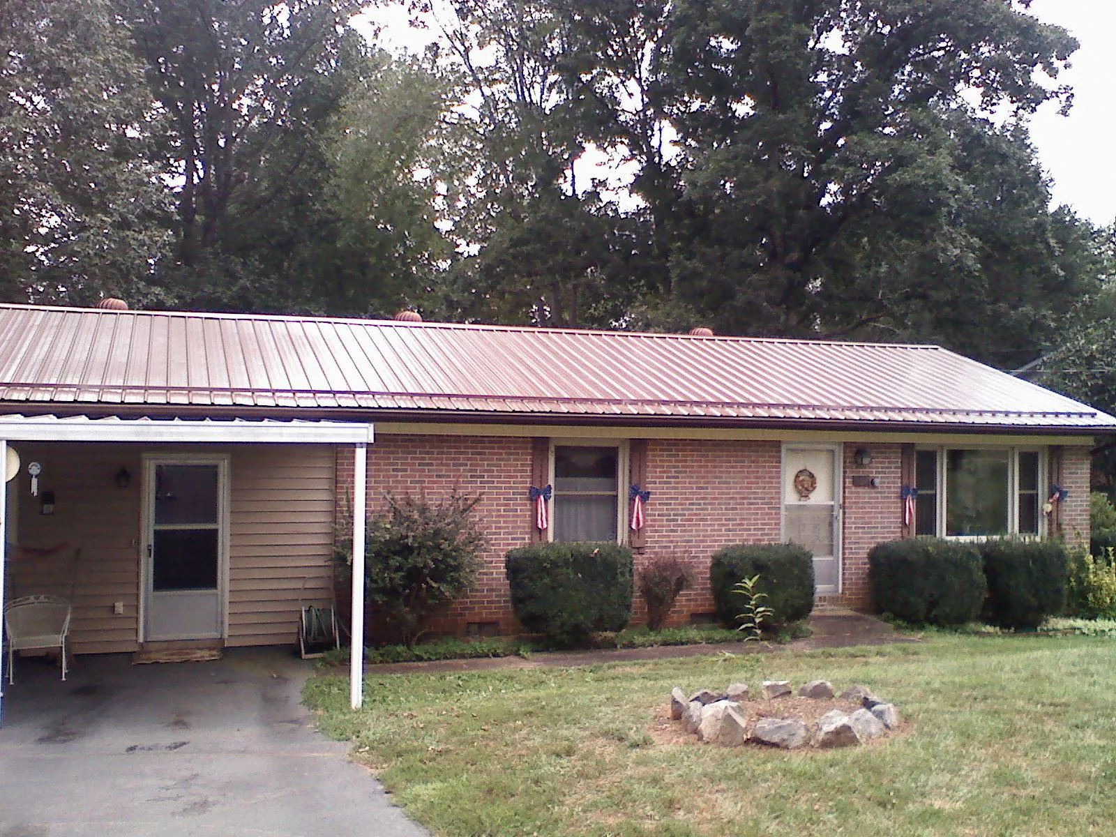 Bronze metal roof and carport on a brick ranch home — Roof Repair work by our crew in Harbeson