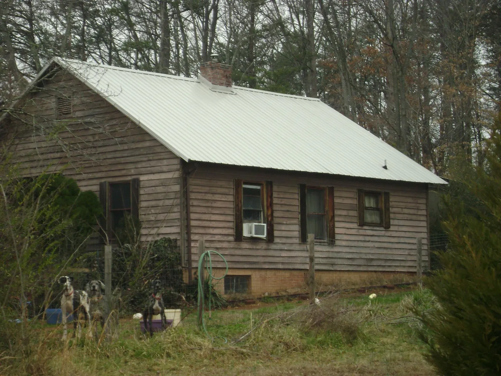 White metal roof on an old wood sided farmhouse, from a Metal Roof Installation job in Harbeson